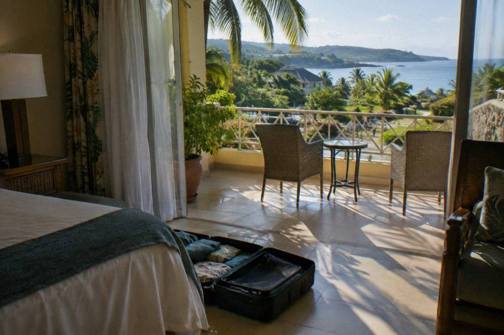 Quick-dry shirts and swim shorts laid out on a bed beside a towel and sunscreen