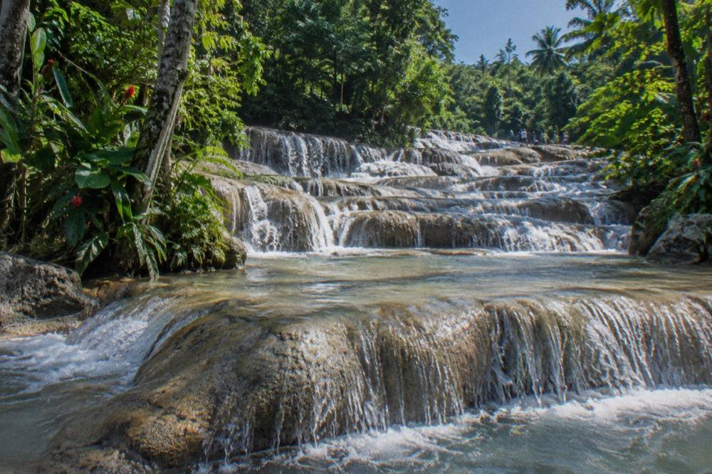 Water cascading over stepped limestone terraces at a tropical waterfall