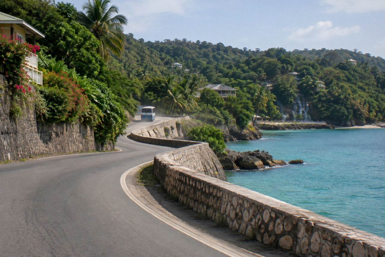 Coastal highway curving along the green shoreline of the Jamaican north coast with calm turquoise water