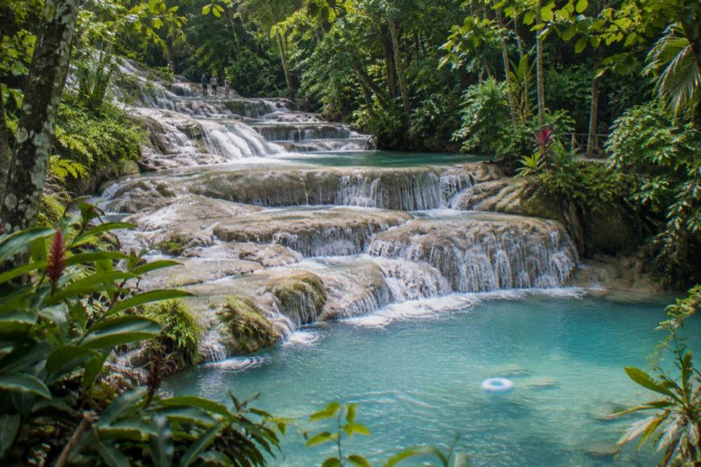 Clear turquoise pools between terraced rock steps of a waterfall