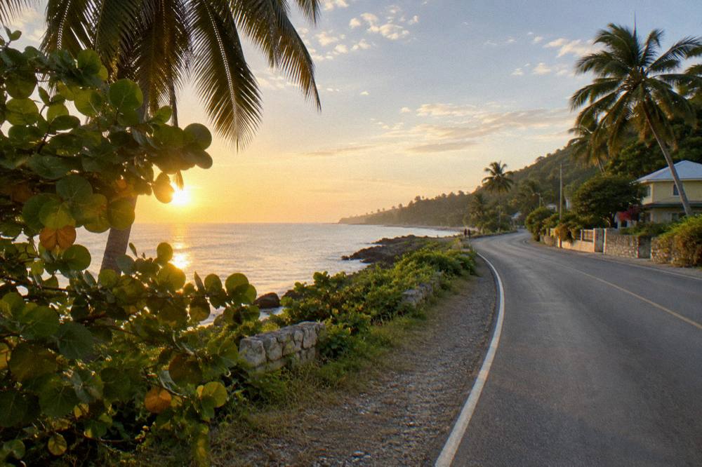 Coastal highway curving along a green Jamaican shoreline toward Ocho Rios