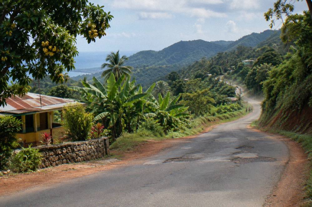 Winding mountain road climbing through lush green hills in rural Jamaica