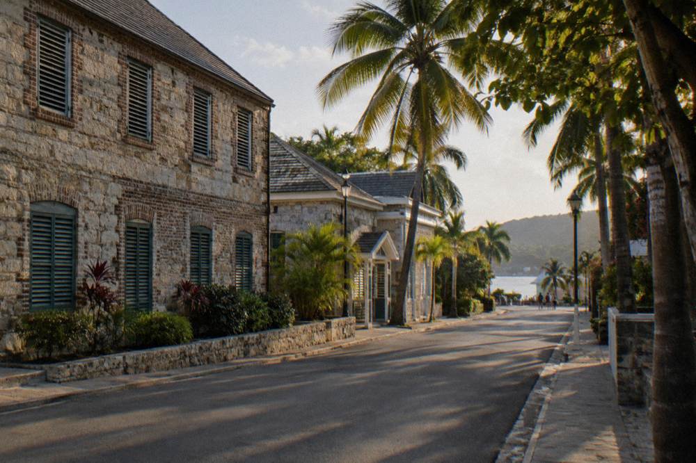 Georgian stone buildings along a quiet Caribbean town street with parked cars