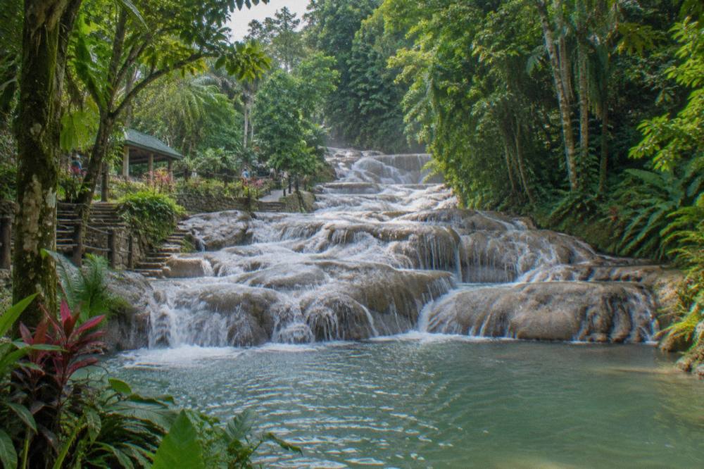 Waterfall terraces spilling into a rocky pool surrounded by tropical forest
