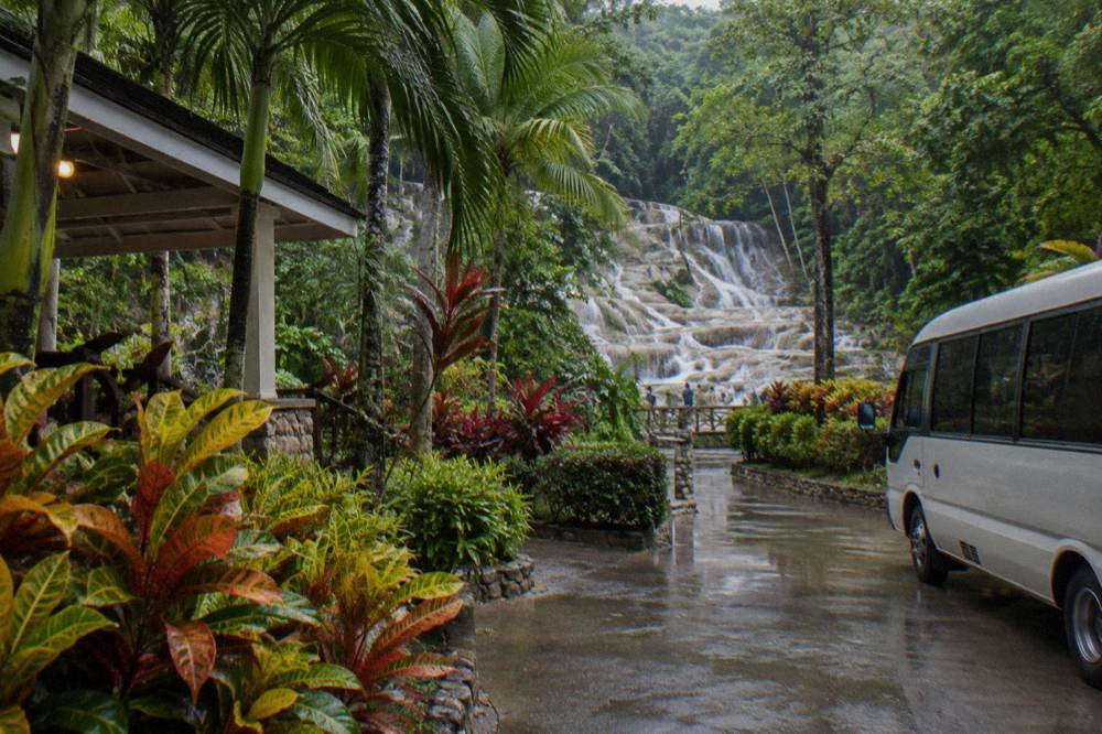 Signposted entrance plaza of a waterfall park with tropical planting