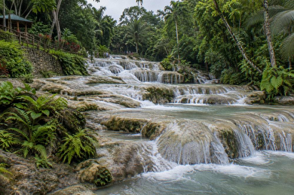 Waterfall terraces at Dunn's River Falls with water flowing over pale rock steps