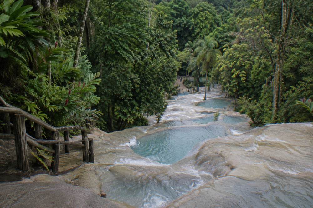 Turquoise pools collected in limestone ledges along a descending waterfall