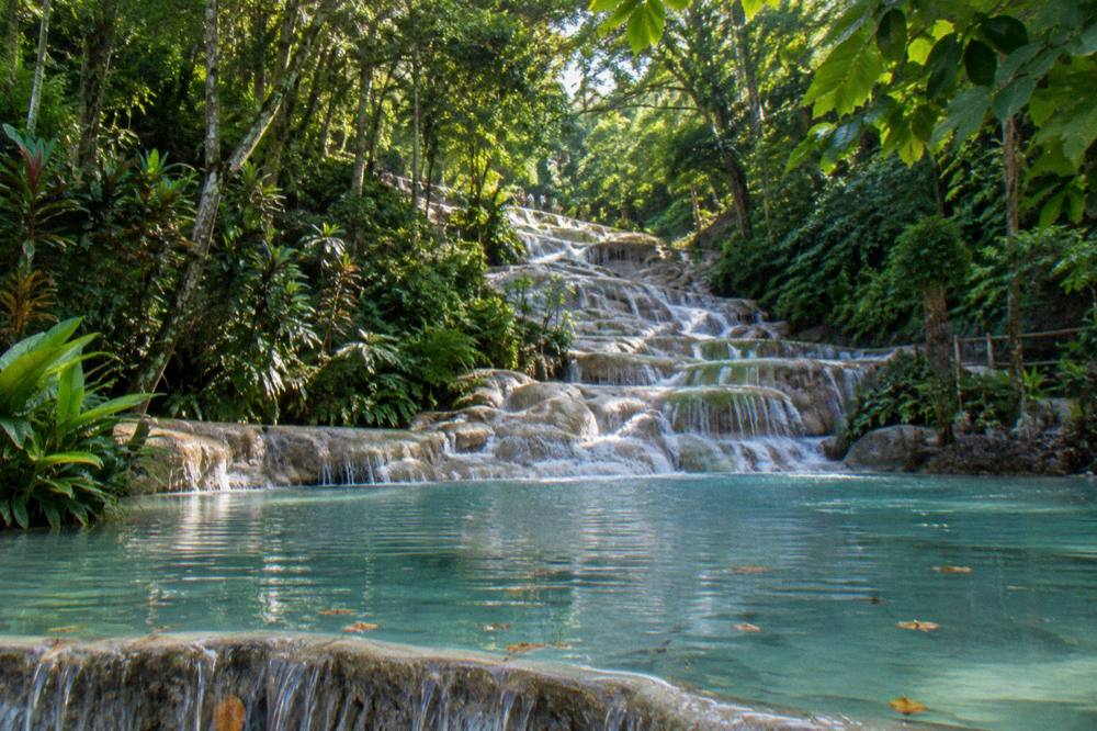 A calm shallow pool at the bottom of a terraced waterfall