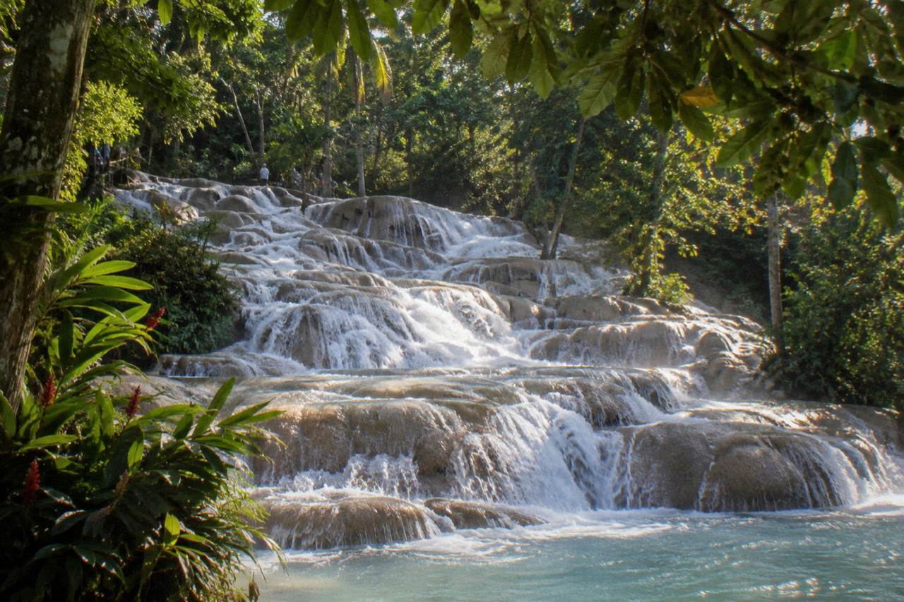 Water cascading over terraced limestone steps at a tropical waterfall
