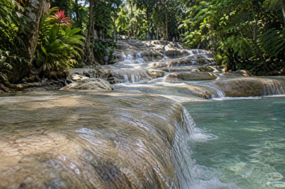 Waterfall terraces with water flowing over smooth limestone steps into a shallow pool