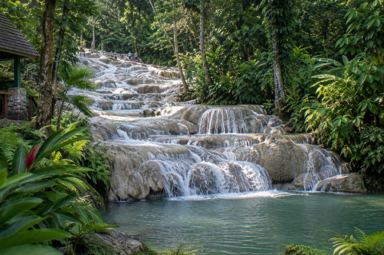 Terraced limestone waterfall cascading into a pool at a tropical park