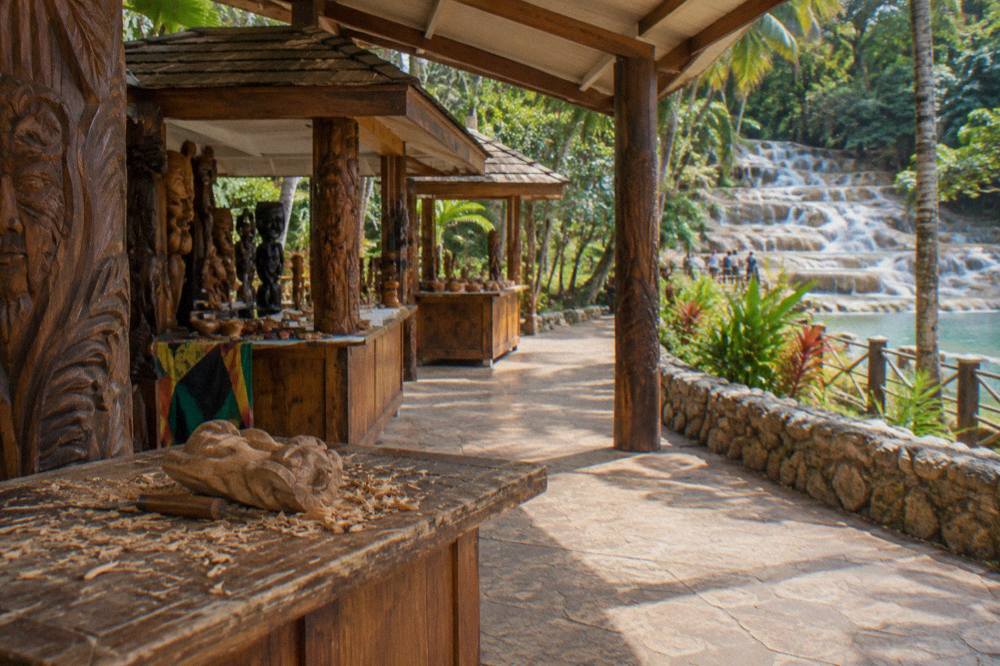 Wooden tour desks and excursion signs along the walkway leading from the Ocho Rios cruise pier