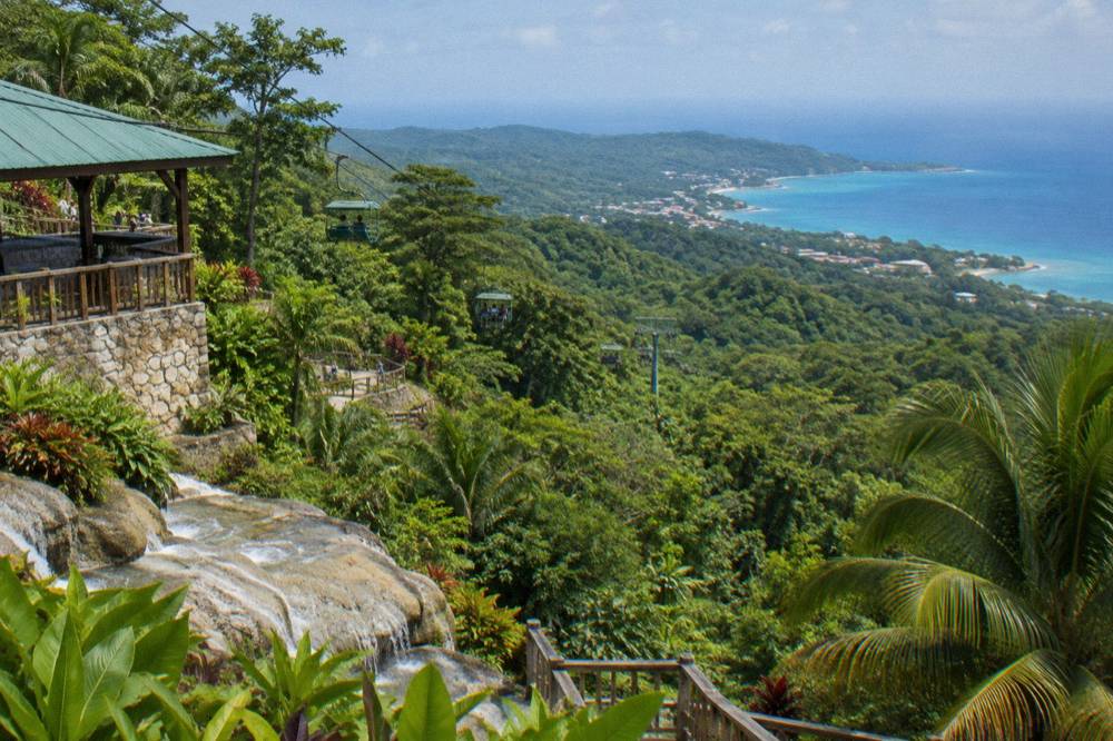 Rainforest canopy and green mountain ridge rising above the Ocho Rios coastline